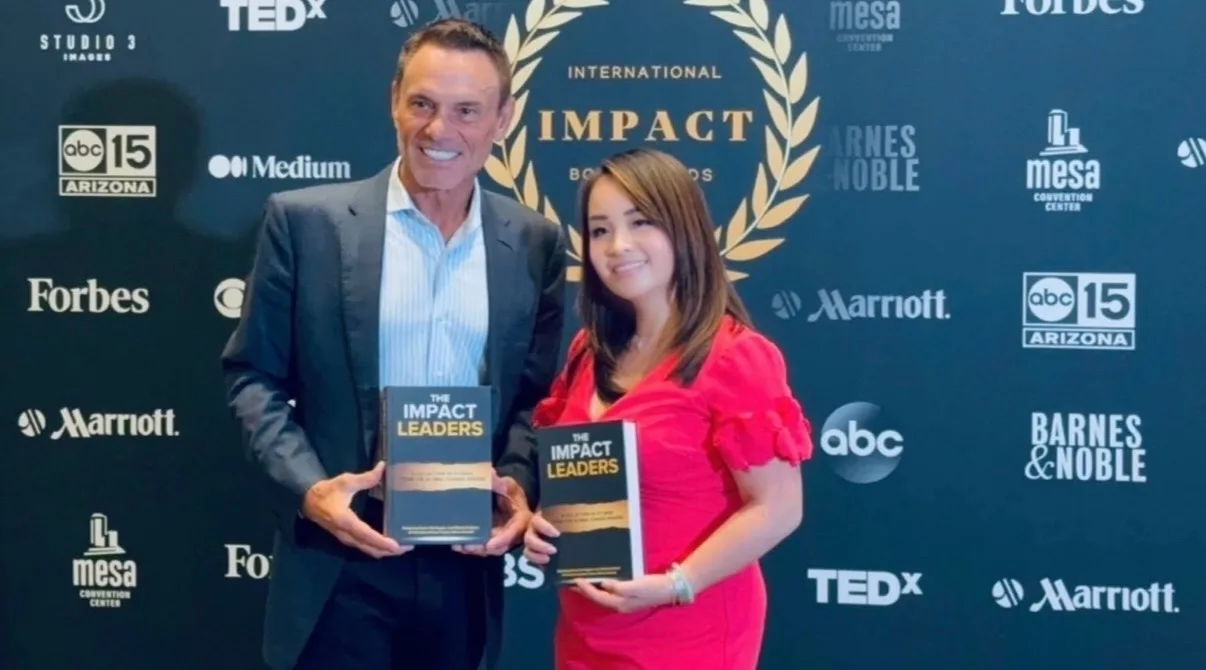 Kevin Harrington and Kimly Hoang-Nakata holding The Impact Leaders at the International Impact Book Awards